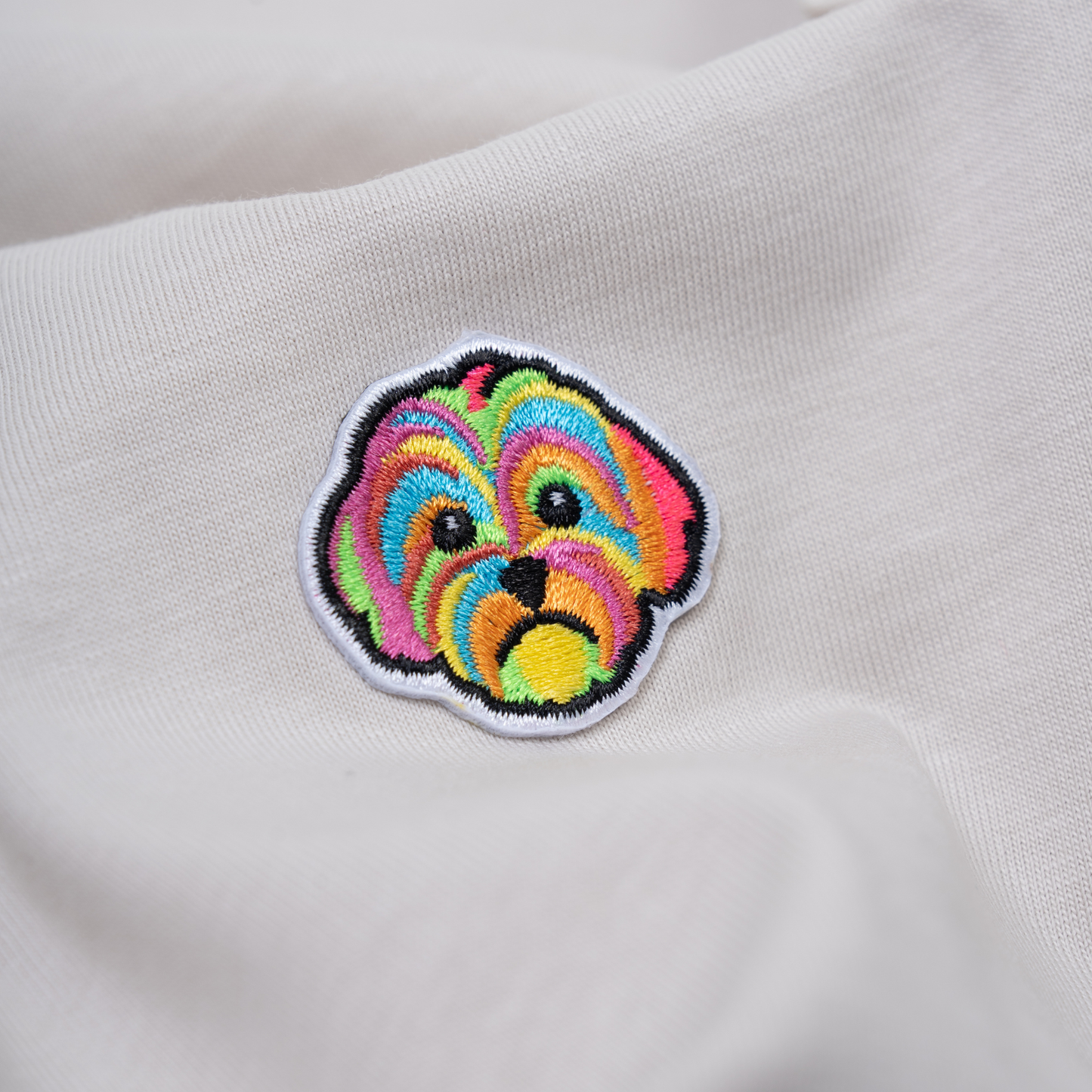 Close up of HIGGS dog logo on oatmeal t-shirt