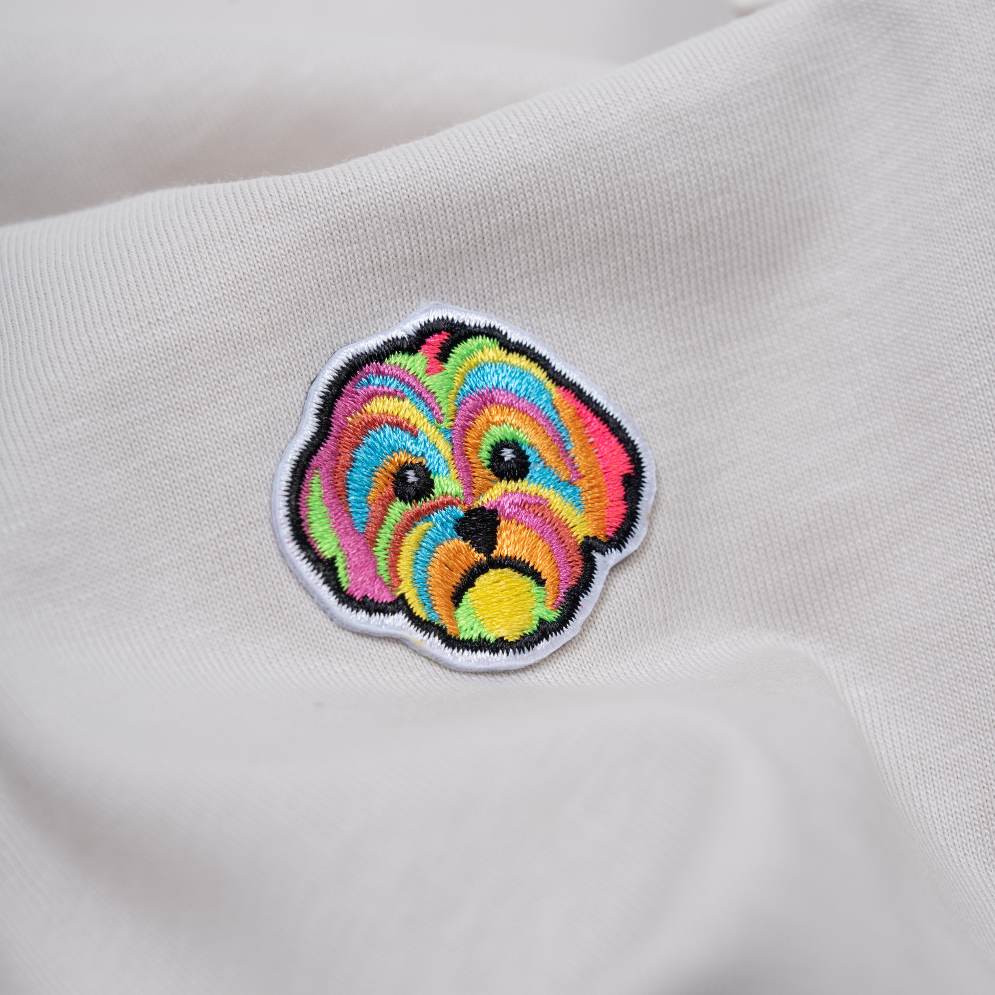 Close up of HIGGS dog logo on oatmeal t-shirt